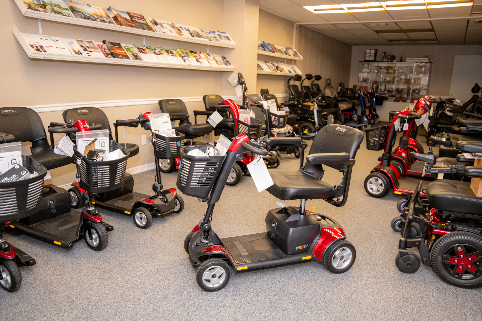 Mobility Scooters: A display floor filled with various designs and types of mobility scooters and power chairs