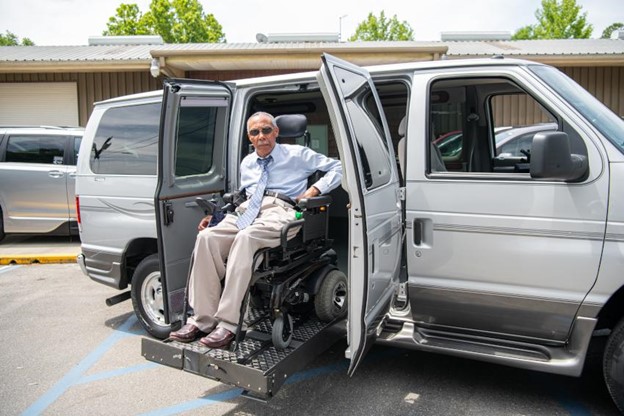 A man in a wheelchair sits in the back of a van, ready to embark on a journey.