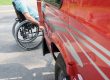 NMEDA QAP Certified Blog Image; back end of a car with a person in a wheelchair in the background.