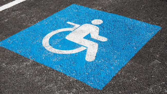 a wheelchair accessible parking spot's emblem painted on concrete