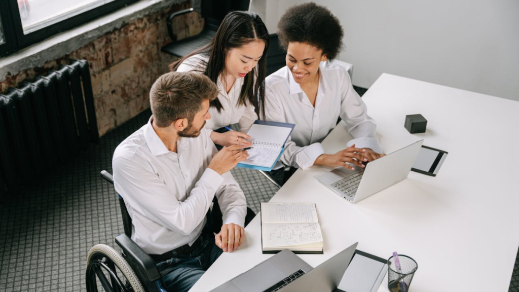 man in wheelchair discussing something in a professional setting, such as a bank