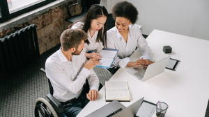 man in wheelchair discussing something in a professional setting, such as a bank